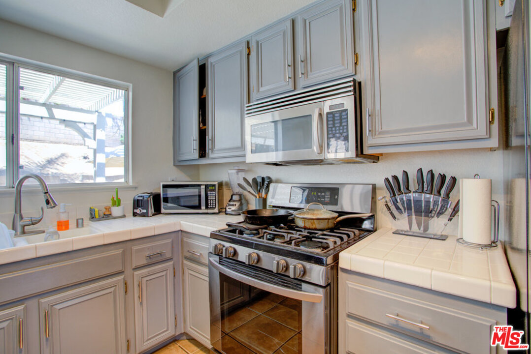 19281 Foxtail Lane Riverside, CA 92508 - Photo 17 of 53 a kitchen with stainless steel appliances granite countertop a stove a sink and a microwave