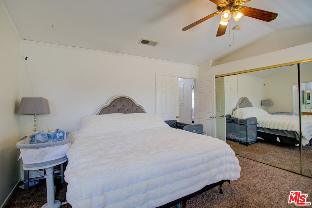 19281 Foxtail Lane Riverside, CA 92508 - Photo 34 of 53 a bedroom with a bed and a chandelier