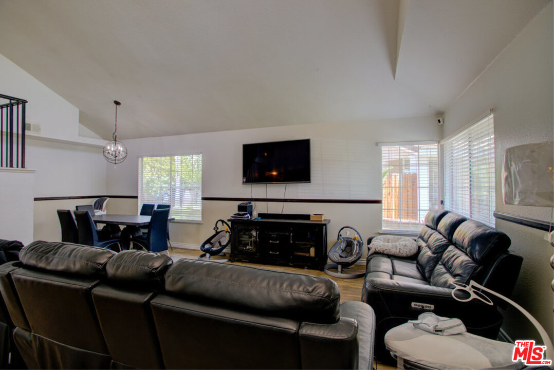 19281 Foxtail Lane Riverside, CA 92508 - Photo 6 of 53 a living room with furniture a large window and a flat screen tv