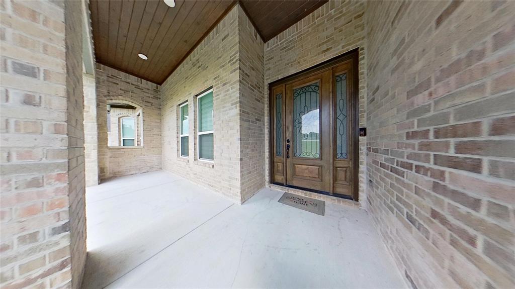 3248 North Cardinal Road Azle, TX 76020 - Photo 6 of 29 Covered entryway featuring a wood-finish door with decorative glass inserts, brick exterior, and a wood-paneled ceiling