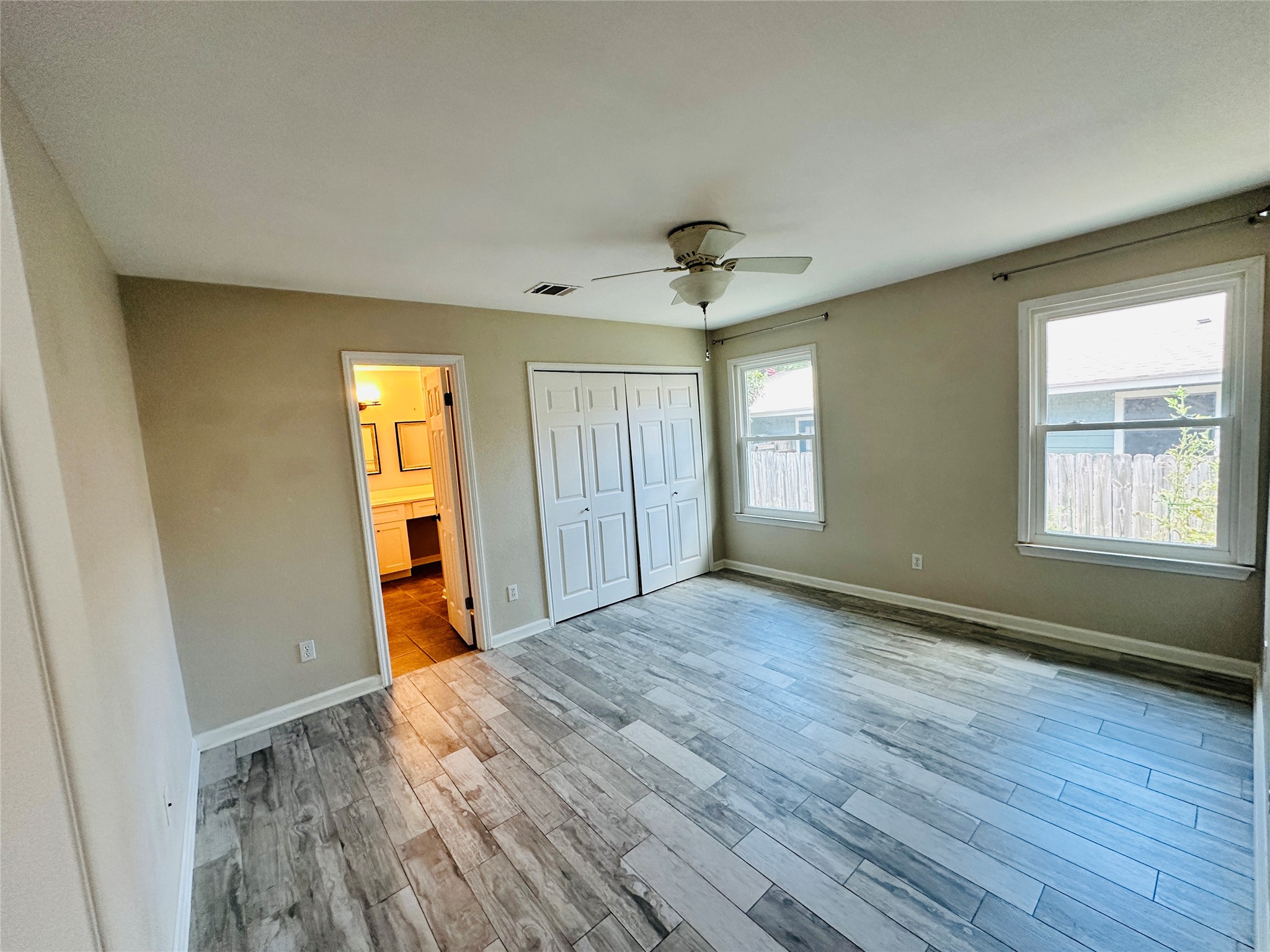 13015 Garfield Lane Austin, TX 78727 - Photo 14 of 16 Unfurnished bedroom with light wood-style flooring, a closet, ceiling fan, and ensuite bathroom
