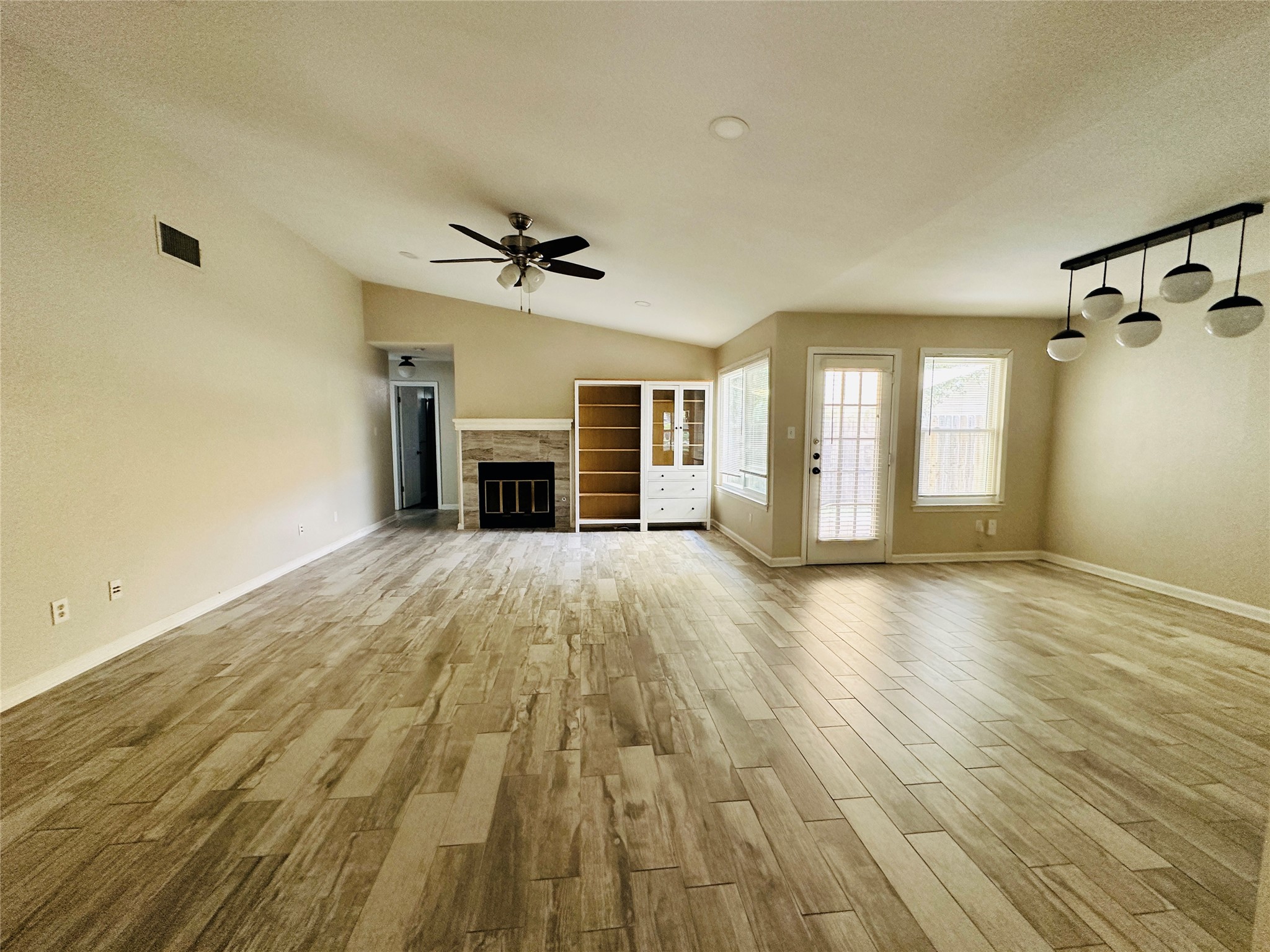 13015 Garfield Lane Austin, TX 78727 - Photo 3 of 16 Unfurnished living room with wood finished floors, a glass covered fireplace, and ceiling fan