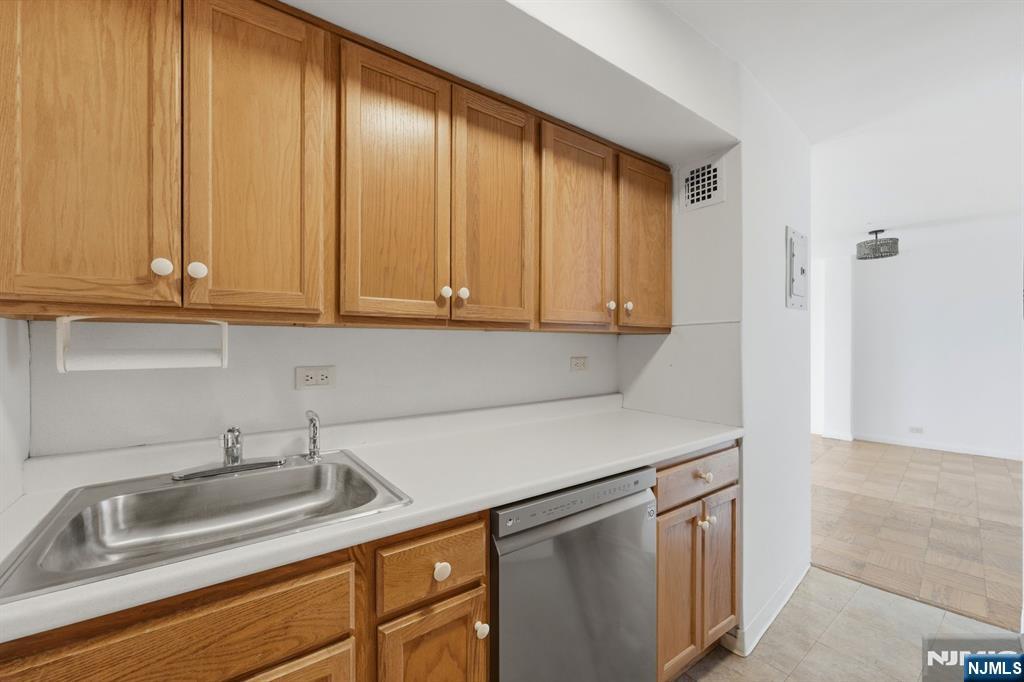 265 Main Street, Unit 704 Ridgefield Park, NJ 07660 - Photo 12 of 23 a kitchen with stainless steel appliances granite countertop white cabinets sink and dishwasher