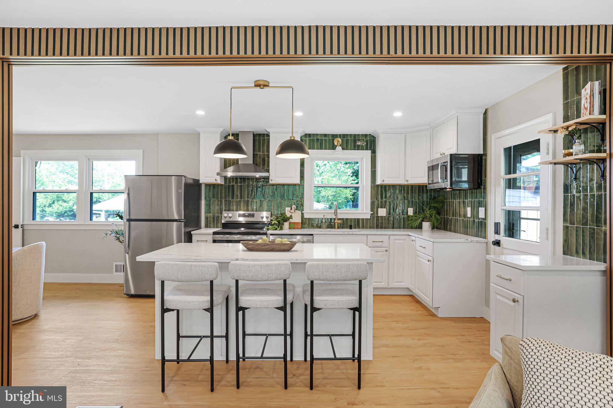 12300 La Plata Street Silver Spring, MD 20904 - Photo 2 of 45 a kitchen with stainless steel appliances kitchen island granite countertop a table chairs and a refrigerator