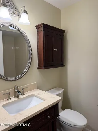 a bathroom with a granite countertop toilet sink and mirror