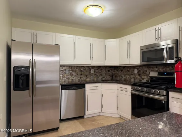 a kitchen with a refrigerator stove and microwave