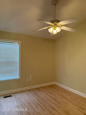 a view of a room with a window and wooden floor