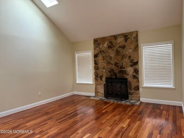 wooden floor fireplace and windows in an empty room