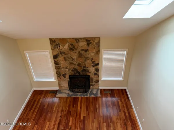 a view of a livingroom with wooden floor and a fireplace