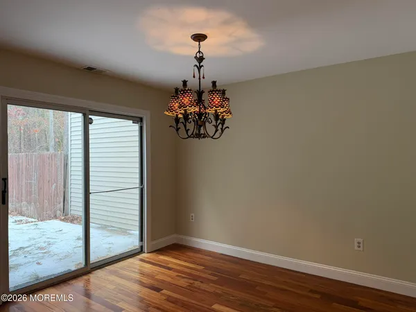a view of a chandelier in big room and wooden floor
