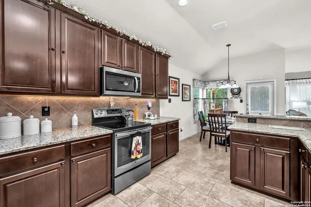 a kitchen with stainless steel appliances granite countertop a stove a sink dishwasher a microwave oven with granite countertops and cabinets