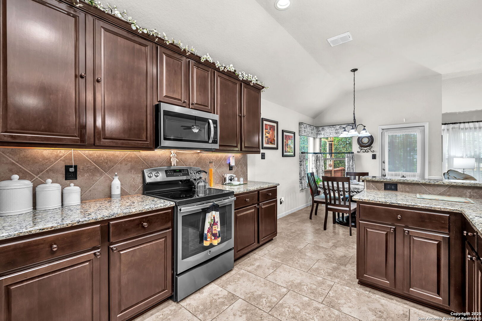 5809 Devonwood Street Schertz, TX 78108 - Photo 14 of 26 a kitchen with stainless steel appliances granite countertop a stove a sink dishwasher a microwave oven with granite countertops and cabinets