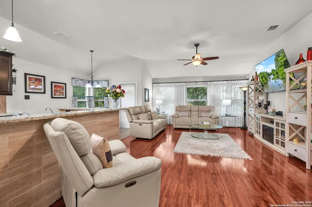 a living room with furniture and a wooden floor