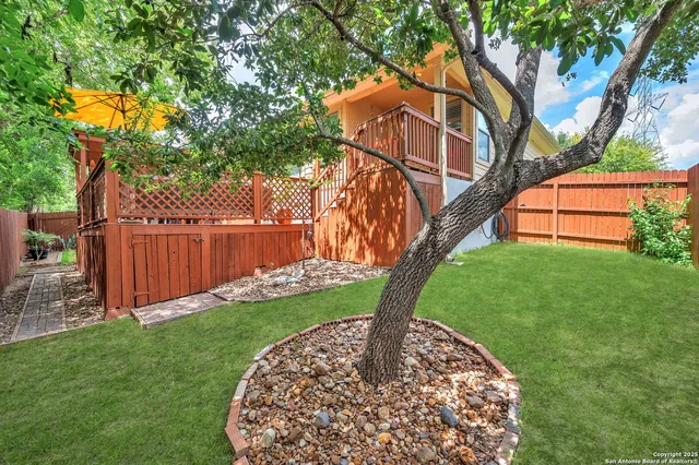 a view of a backyard with wooden fence