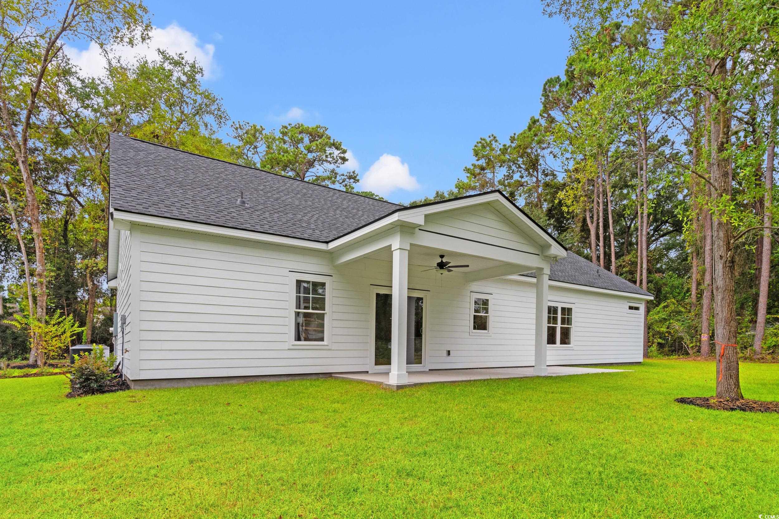 220 Ford Road Pawleys Island, SC 29585 - Photo 15 of 18 Rear view of house featuring a shingled roof, ceiling fan, a patio, and a lawn