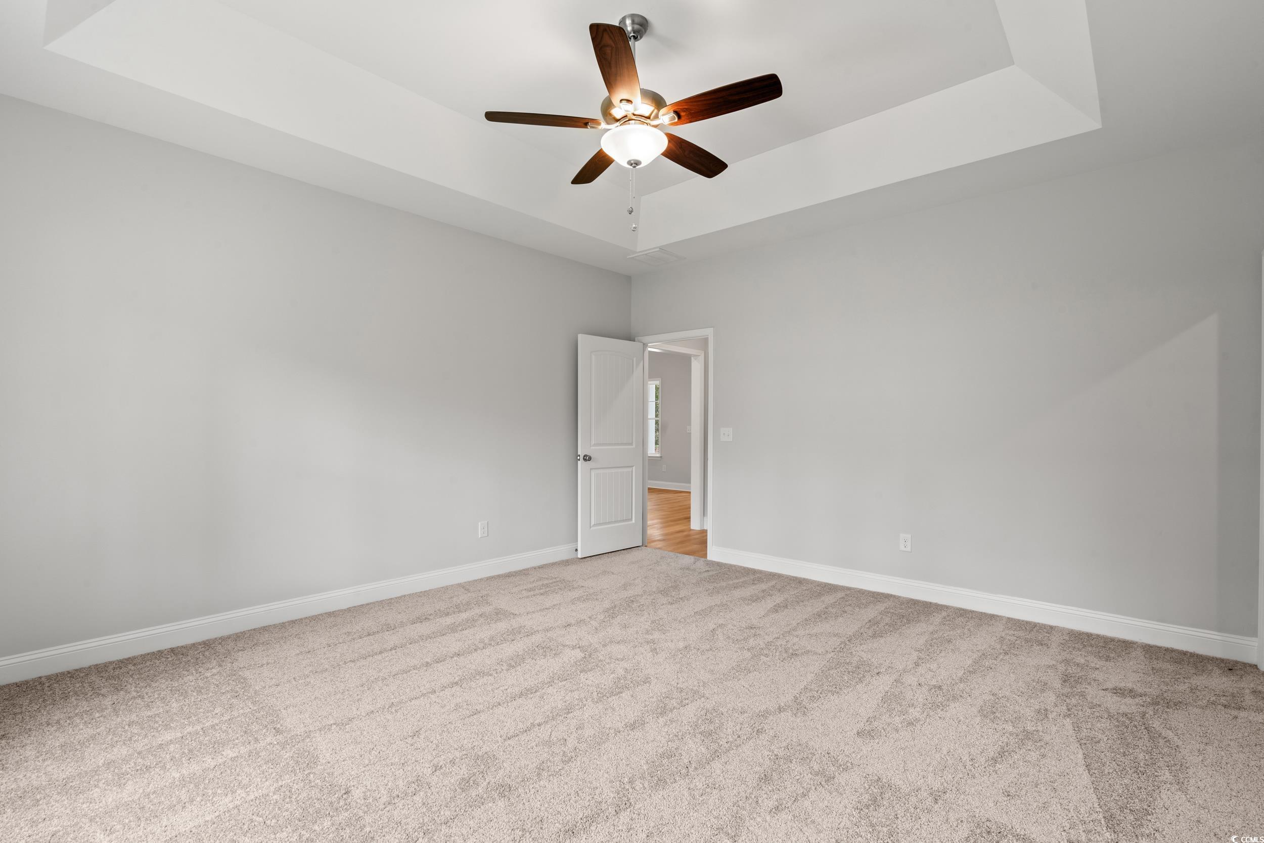 220 Ford Road Pawleys Island, SC 29585 - Photo 5 of 18 Spare room with a raised ceiling, light carpet, and ceiling fan
