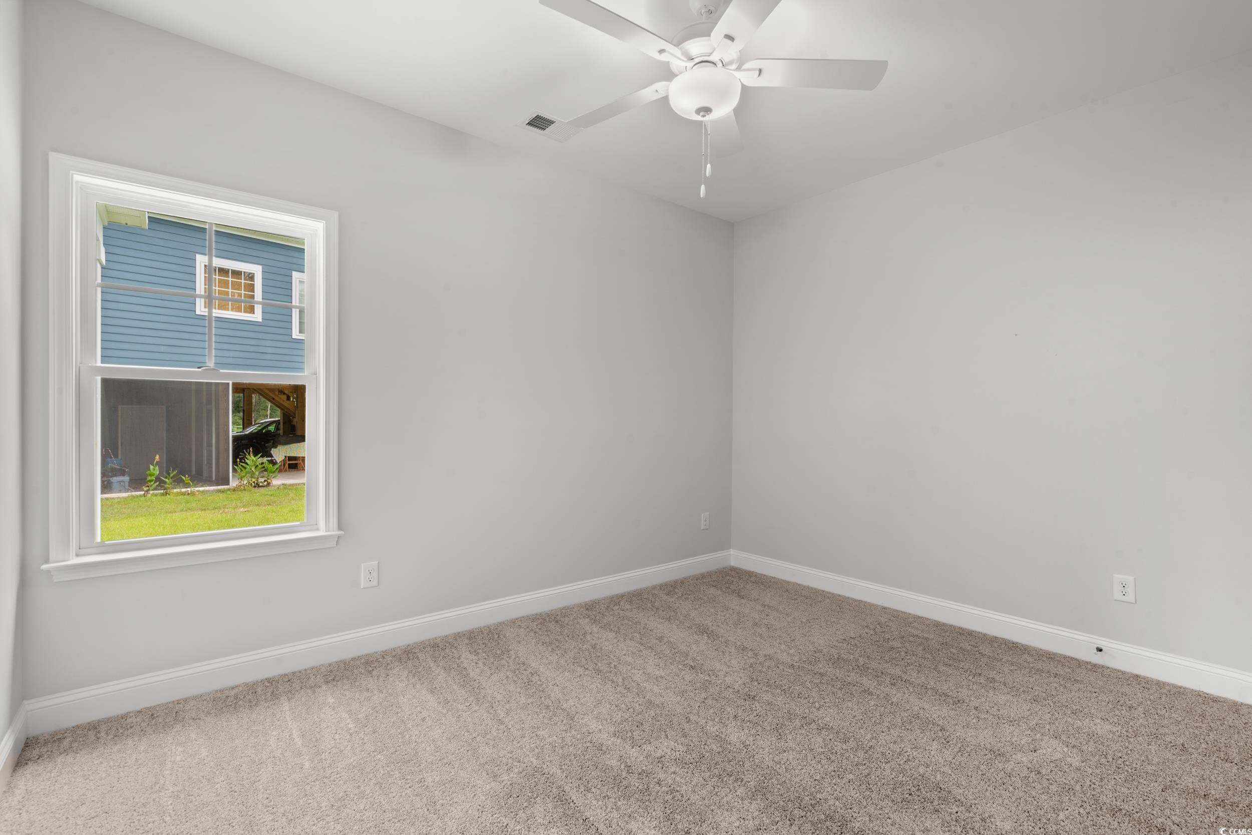220 Ford Road Pawleys Island, SC 29585 - Photo 9 of 18 Spare room featuring carpet flooring and a ceiling fan