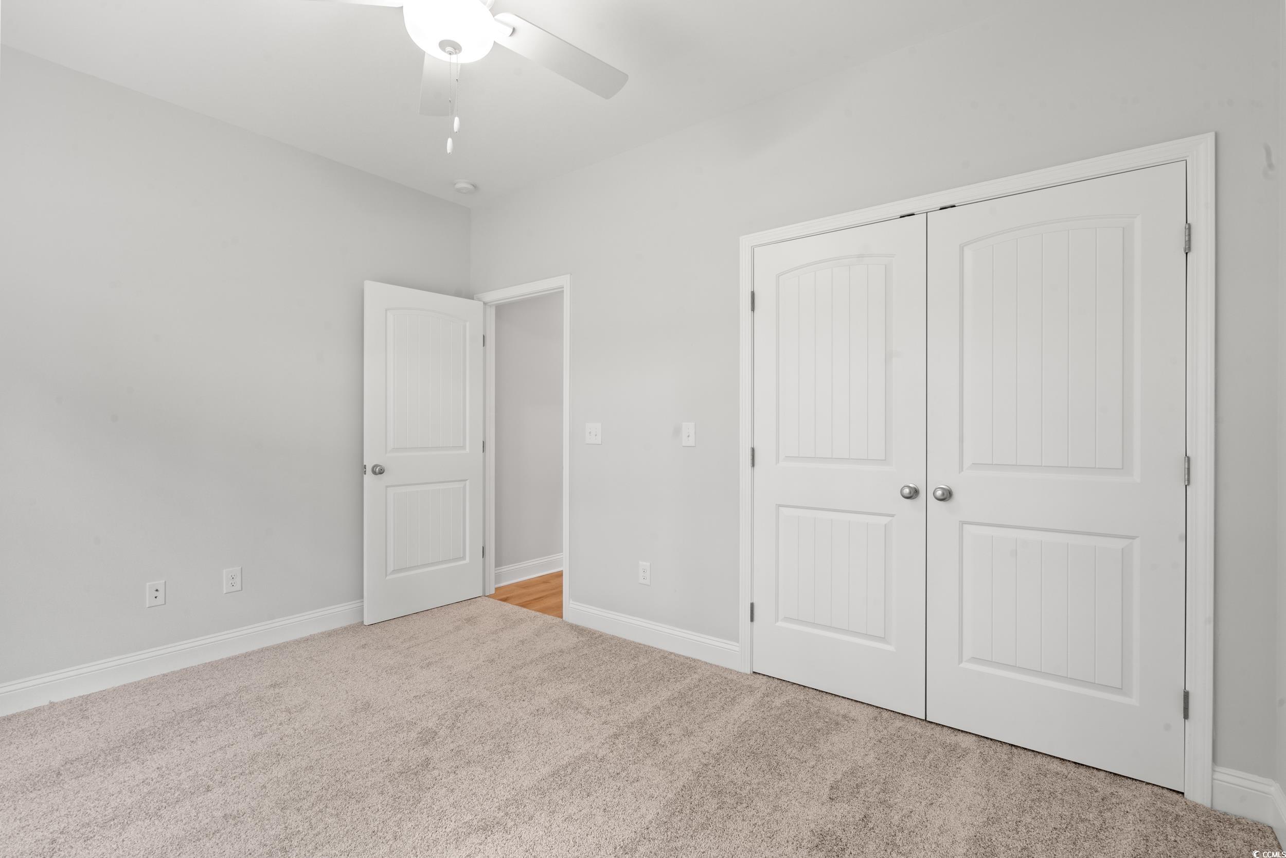 220 Ford Road Pawleys Island, SC 29585 - Photo 10 of 18 Unfurnished bedroom with light carpet, a closet, and ceiling fan