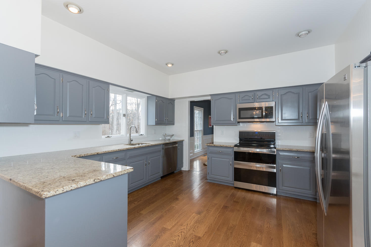 7 Hunt Road Darien, CT 06820 - Photo 8 of 40 a kitchen with stainless steel appliances granite countertop a stove top oven a sink and dishwasher a refrigerator with wooden floor