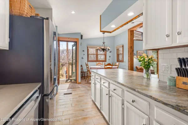 a kitchen with stainless steel appliances granite countertop a sink and a refrigerator