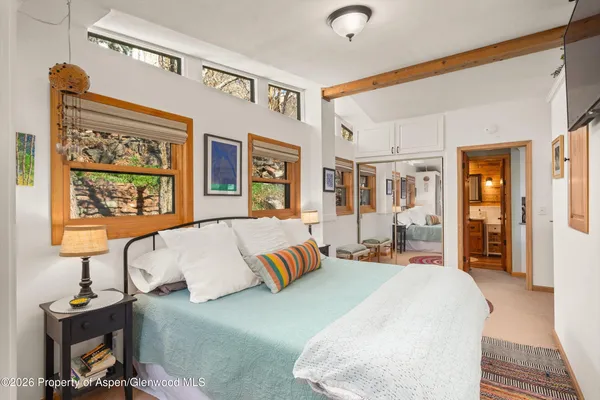 a bedroom with a bed and dresser with mirror