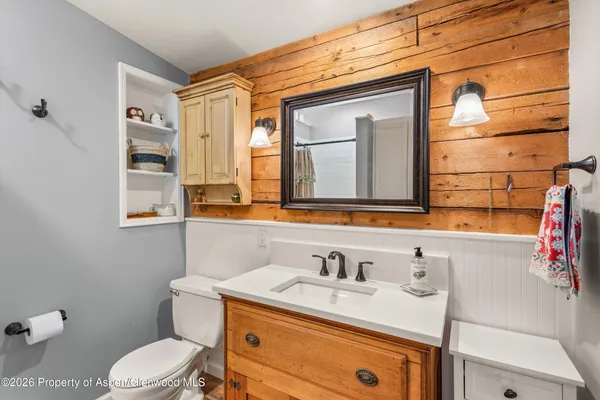 a bathroom with a granite countertop toilet sink and mirror