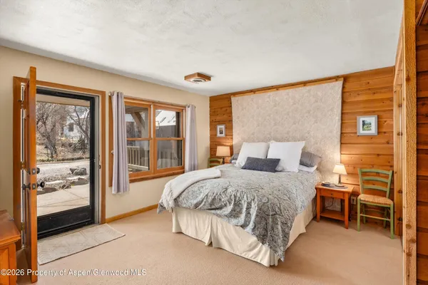 a bedroom with a bed and a dresser next to a window
