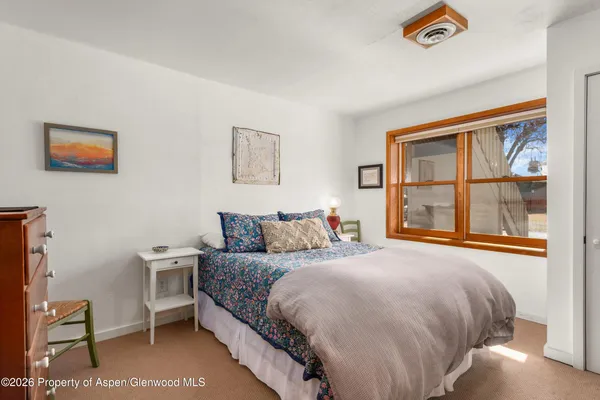 a bedroom with a bed and a large window