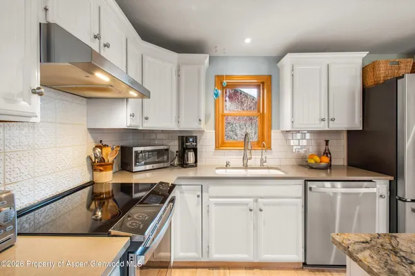 a kitchen with stainless steel appliances a stove a sink a refrigerator and cabinets