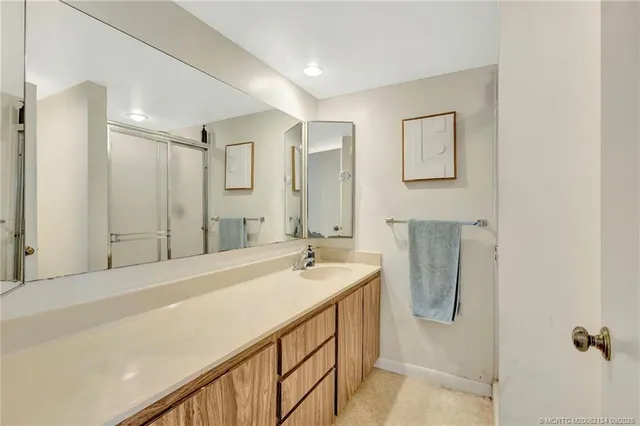 a spacious bathroom with a shower sink and mirror