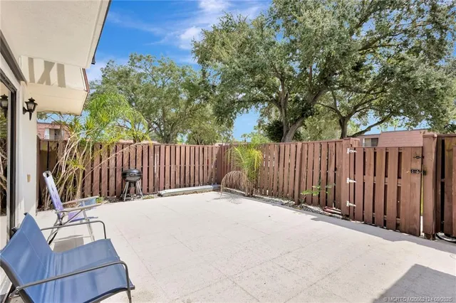 a view of backyard with wooden fence and trees