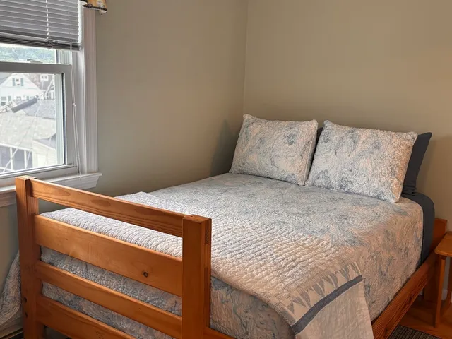 a bed sitting in a bedroom next to a window