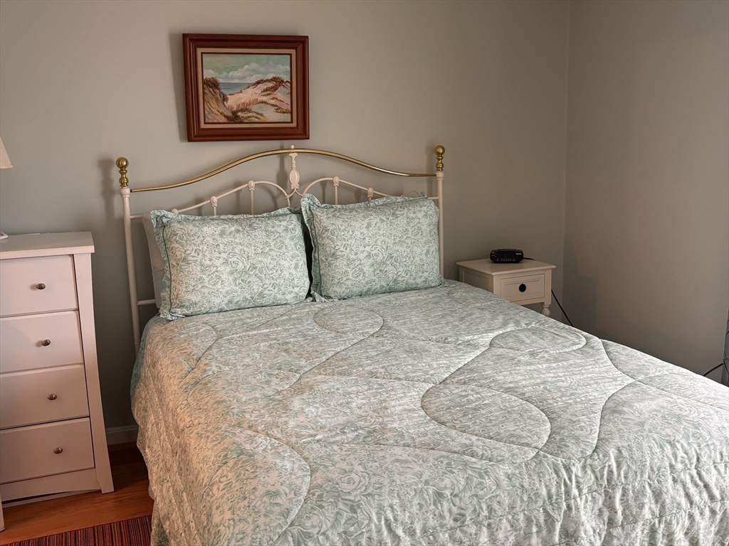 20 Humarock Beach, Unit 1 Scituate, MA 02066 - Photo 13 of 20 a large bed sitting in a bedroom and painting on the wall