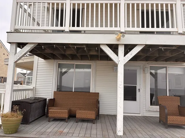 a view of a two chairs and table in the back yard of the house