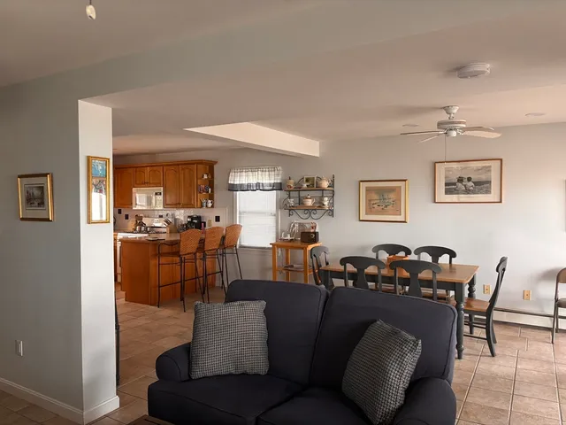 a living room with furniture kitchen view and a wooden floor