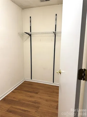 a view of a room with wooden floor and a bathroom