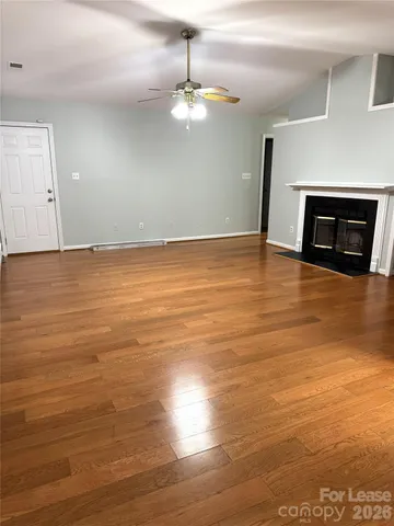 a view of a room with wooden floor and a fireplace