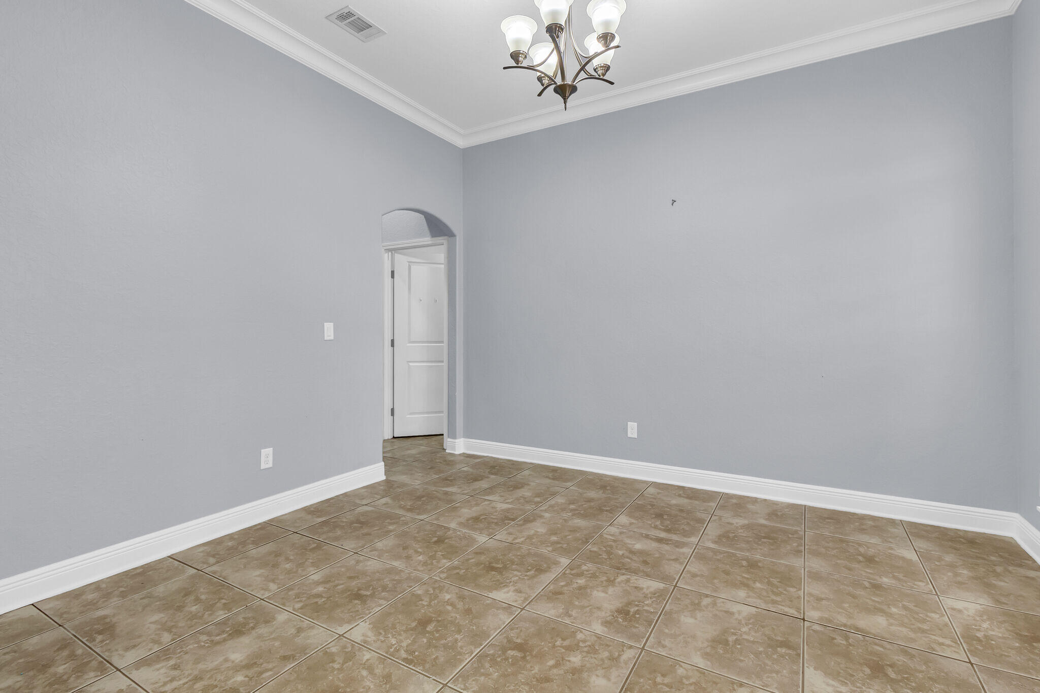 6181 Hummingbird Lane Crestview, FL 32536 - Photo 12 of 46 an empty room with a chandelier fan and windows