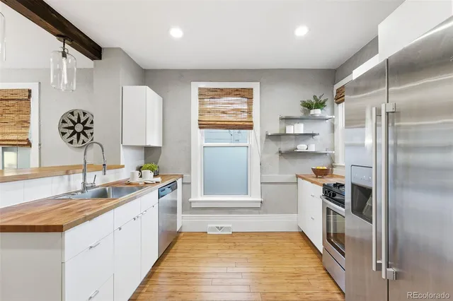 a kitchen with a refrigerator sink and cabinets