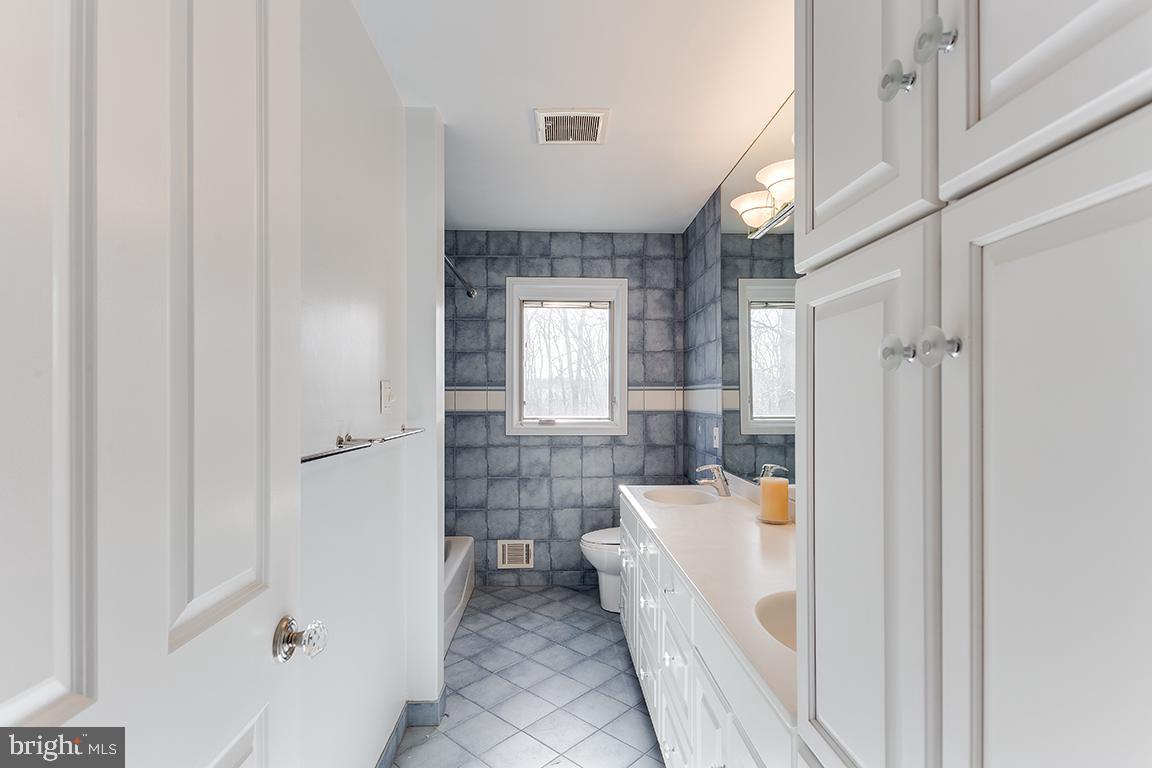 8228 Lakenheath Way Potomac, MD 20854 - Photo 27 of 41 a bathroom with a sink a mirror and a bathtub