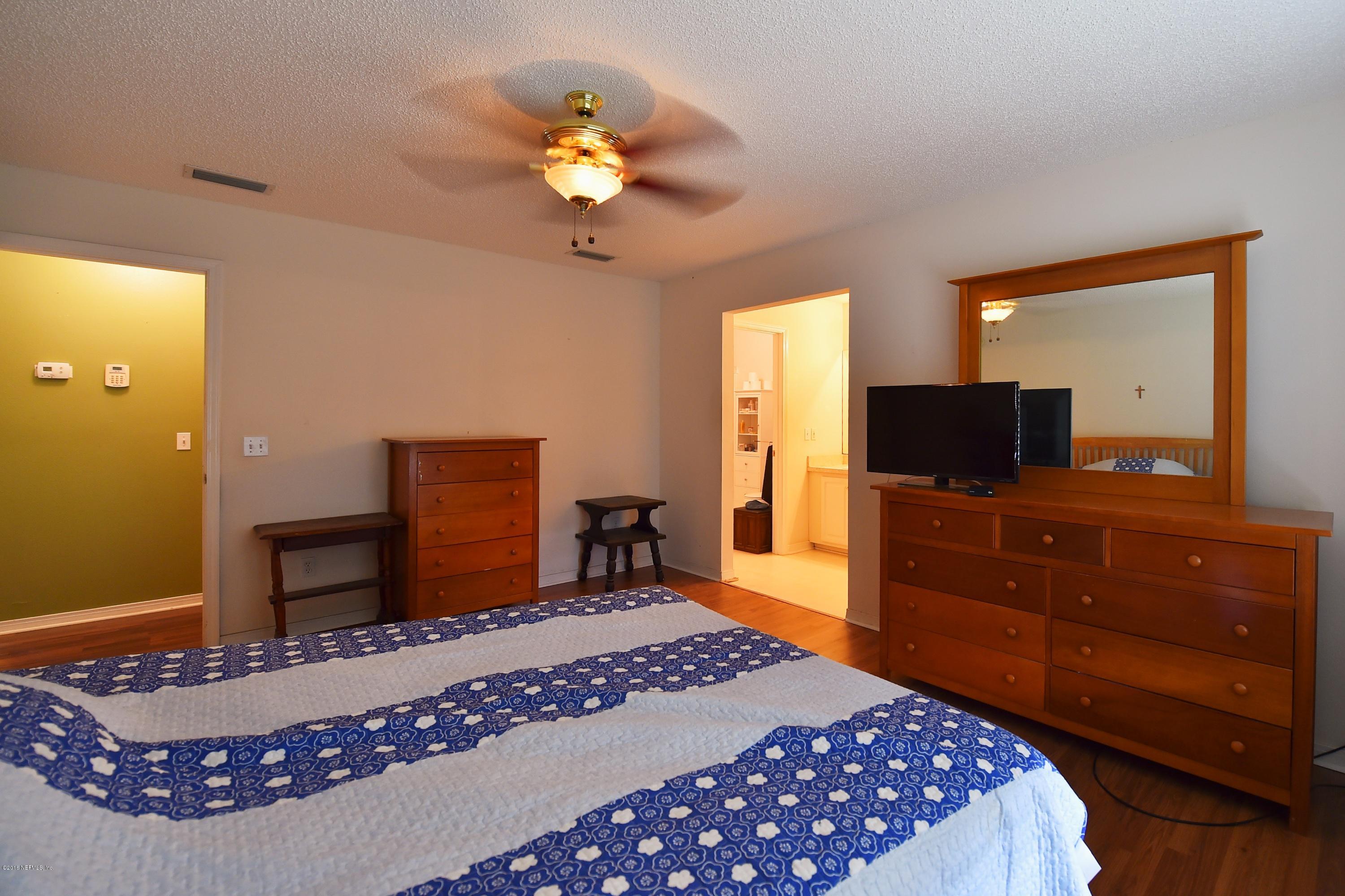 10370 Clayton Mill Road Jacksonville, FL 32221 - Photo 10 of 24 a bedroom with a bed and a chandelier with a dresser