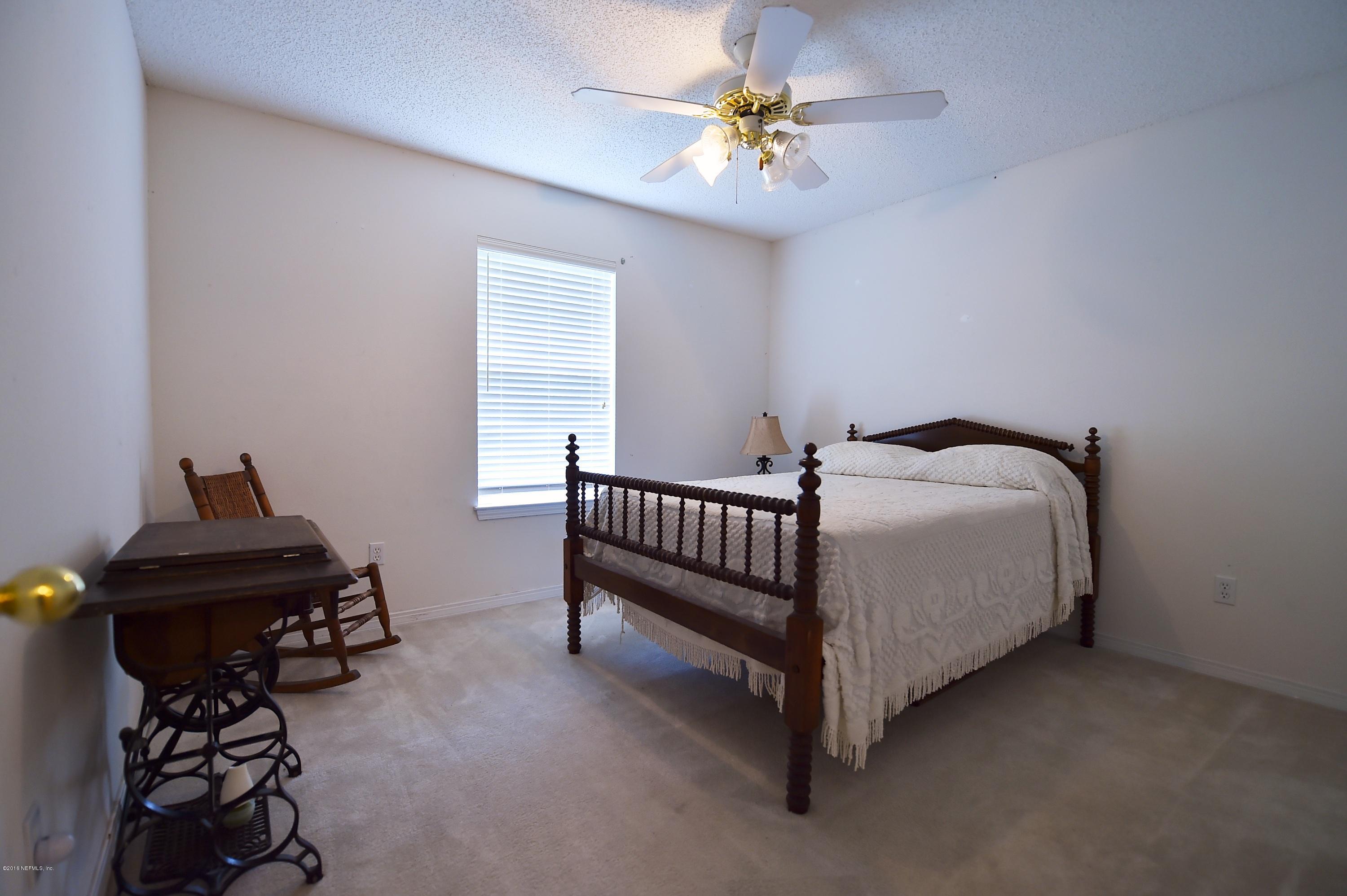 10370 Clayton Mill Road Jacksonville, FL 32221 - Photo 12 of 24 a bedroom with a bed and a chandelier
