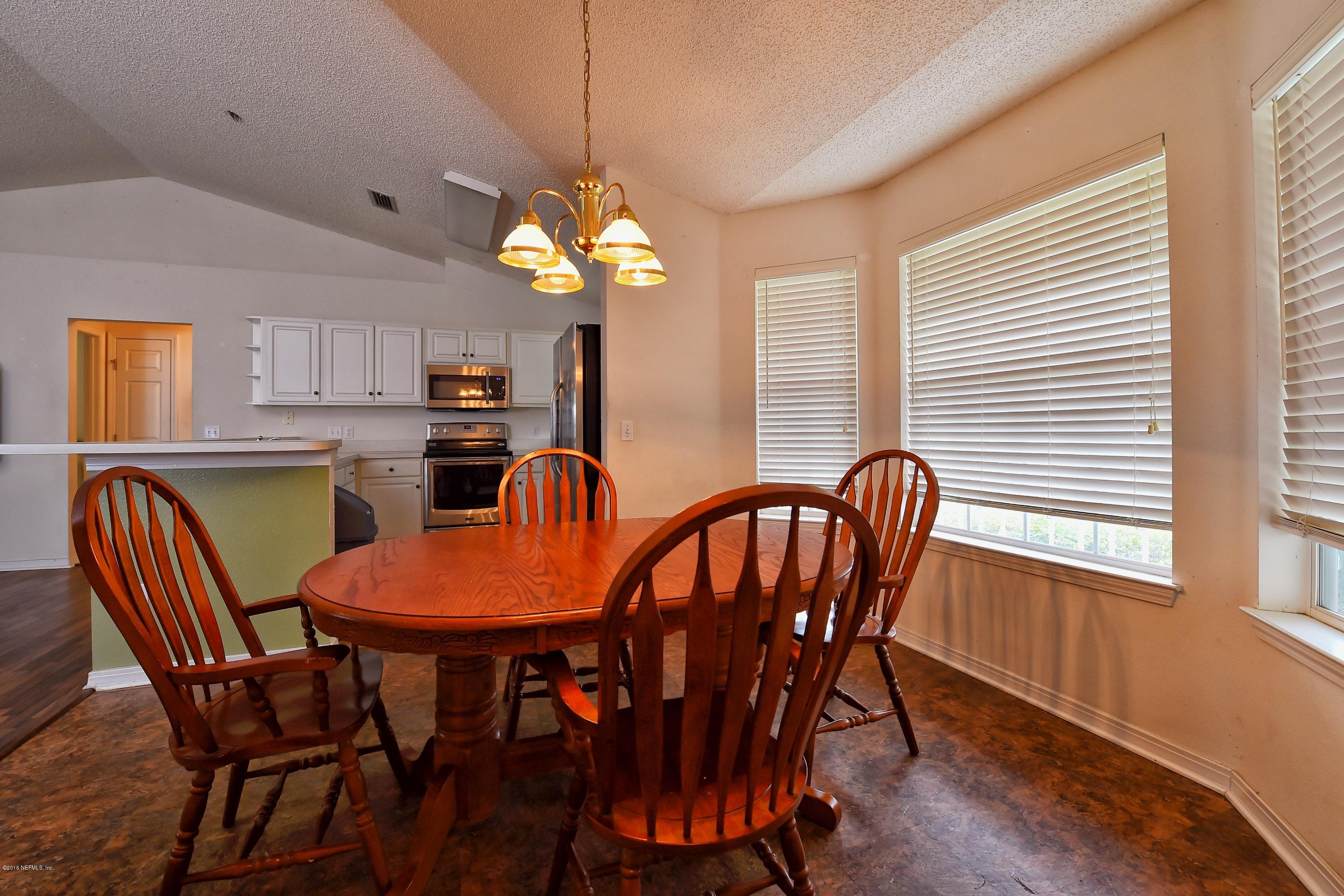 10370 Clayton Mill Road Jacksonville, FL 32221 - Photo 6 of 24 a view of a dining room with furniture a chandelier and wooden floor