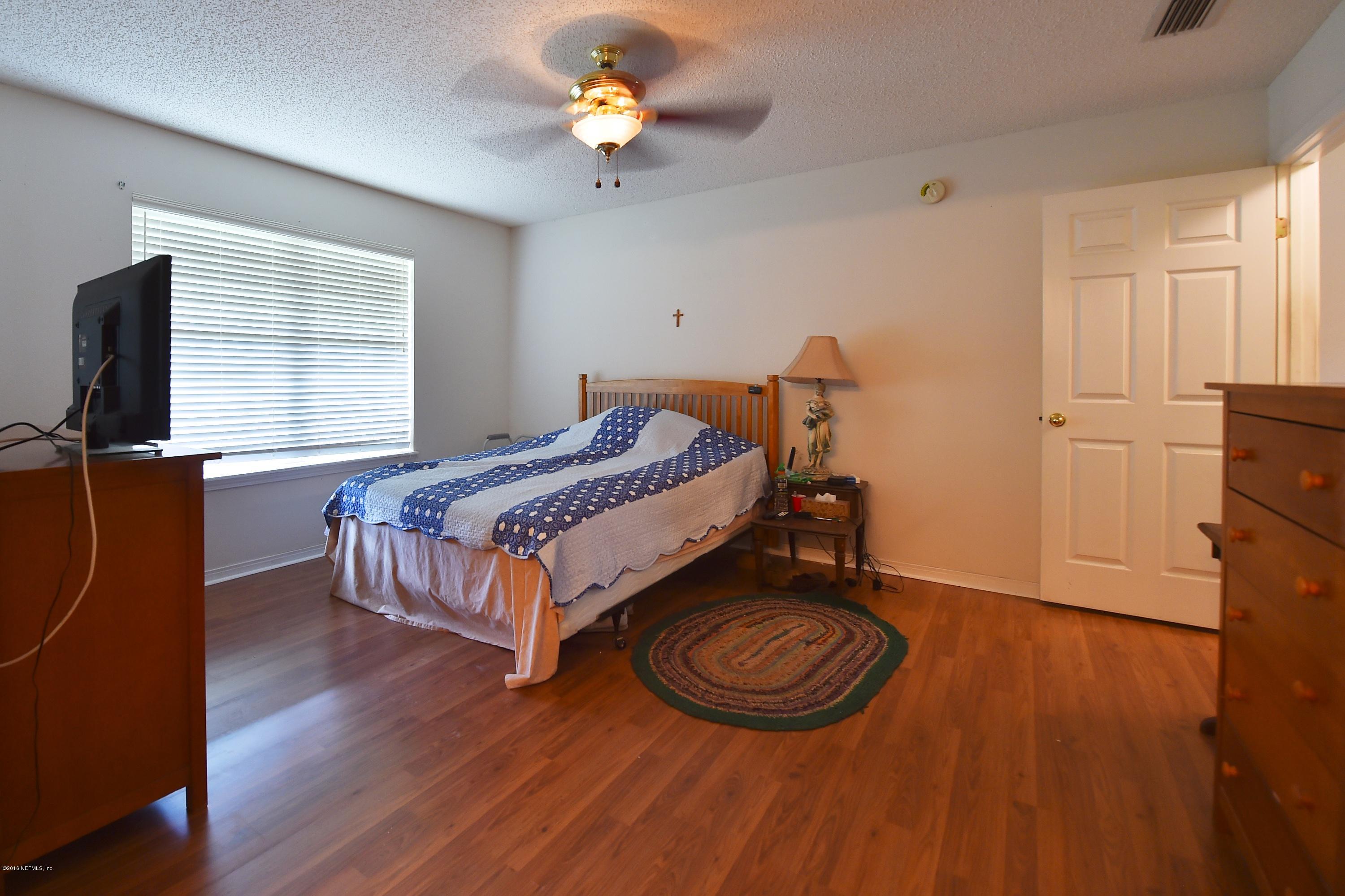 10370 Clayton Mill Road Jacksonville, FL 32221 - Photo 9 of 24 a bedroom with a bed and a chandelier