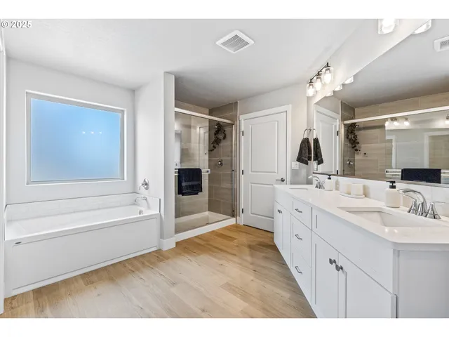 a bathroom with a double vanity sink mirror and shower