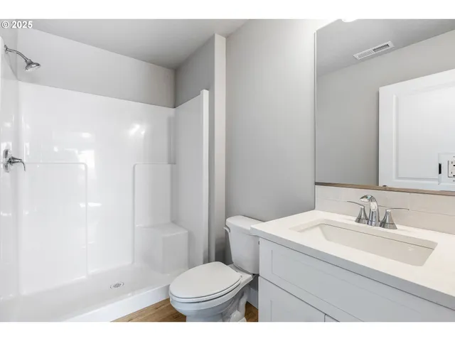 a bathroom with a sink toilet a mirror and shower