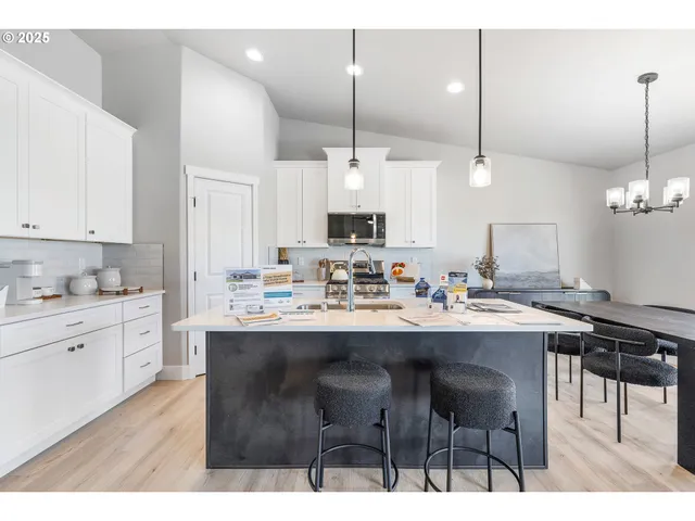 a kitchen with kitchen island granite countertop a sink a center island and cabinets