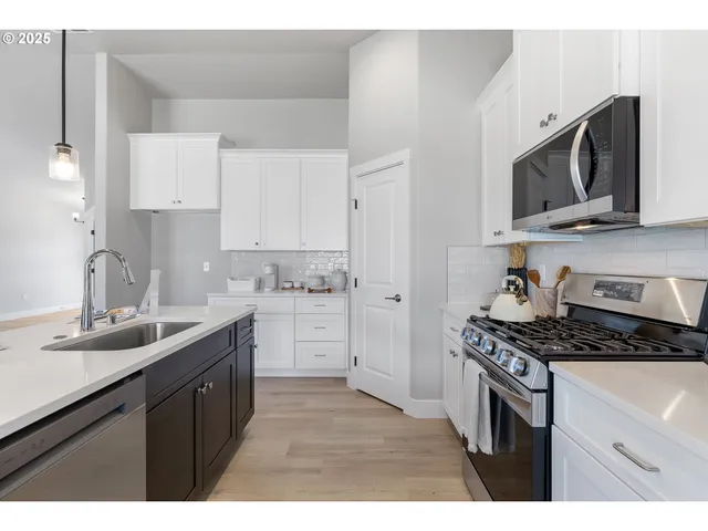 a kitchen with stainless steel appliances a sink stove and microwave