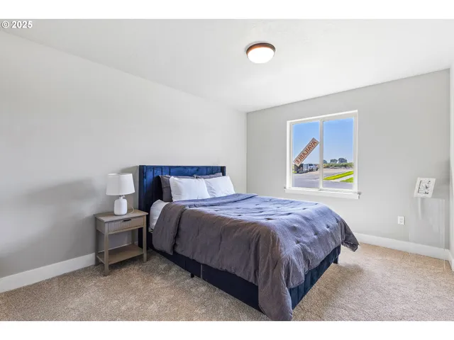 a bedroom with a bed and painting on the wall