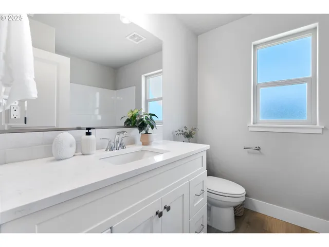 a bathroom with a sink vanity granite toilet and a mirror